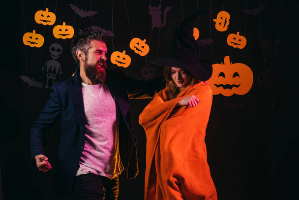 Halloween Family in costumes on black background. Halloween. Man and woman having fun at home. Party and festivals on Halloween. People wearing carnival costumes. - Photo, Image