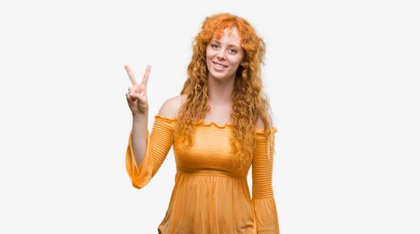Young redhead woman showing and pointing up with fingers number two while smiling confident and happy. - Photo, Image