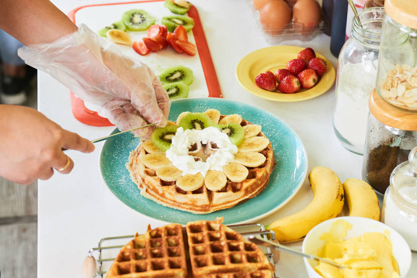 Cooking and putting fresh fruits on waffles - Fotoğraf, Görsel