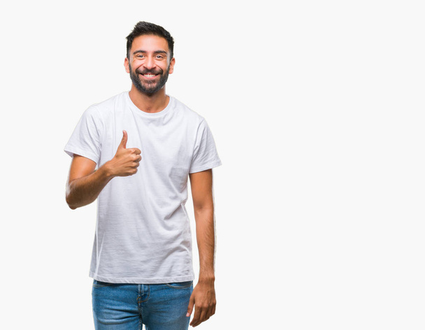Adult hispanic man over isolated background doing happy thumbs up gesture with hand. Approving expression looking at the camera with showing success. - Fotografie, Obrázek