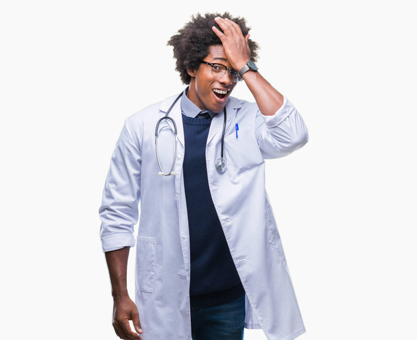 Afro Amerikaanse dokter man over geïsoleerde achtergrond verrast met de hand op het hoofd voor fout, niet vergeten fout. Vergat, slecht geheugen concept. - Foto, afbeelding