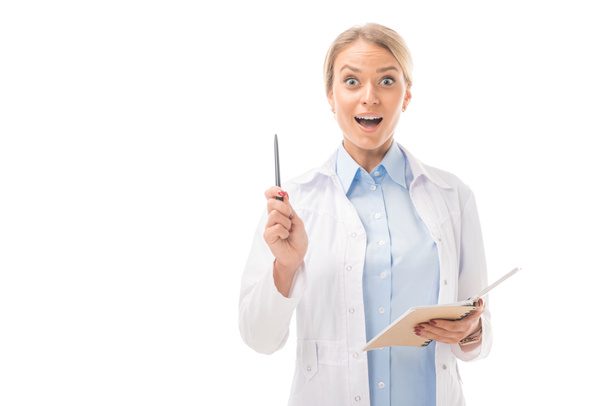 εκφραστική νεαρή γυναίκα γιατρός με δημιουργική ιδέα κρατώντας σημειωματάριο και βλέπουν τα φωτογραφικών μηχανών που απομονώνονται σε λευκό - Φωτογραφία, εικόνα