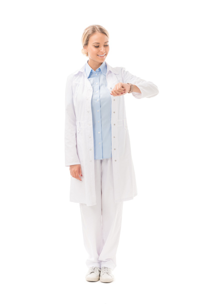 привлекательная молодая женщина врач время проверки с наручными часами изолированы на белом
 - Фото, изображение