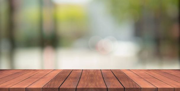 Lege houten tafelblad op natuur groene wazig achtergrond op tuin, ruimte voor montage Toon producten - Foto, afbeelding