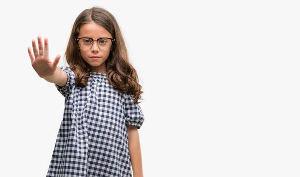 Brunette hispanic girl wearing glasses with open hand doing stop sign with serious and confident expression, defense gesture - Photo, image