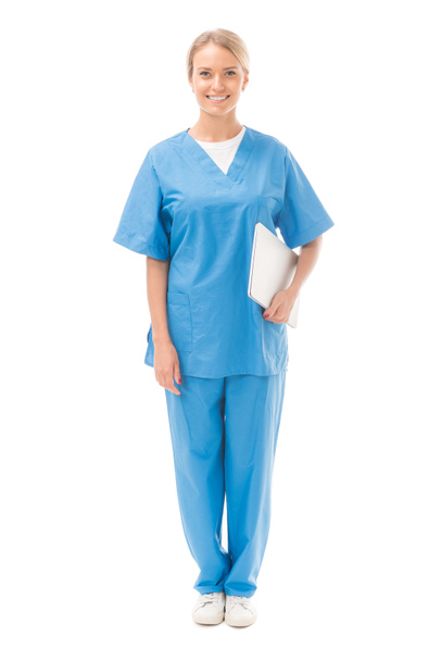 happy young nurse with laptop looking at camera isolated on white - Photo, image