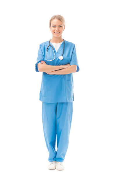 enfermera joven con brazos cruzados mirando a la cámara aislada en blanco
 - Foto, Imagen