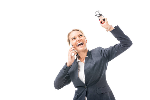 expressive young businesswoman talking by phone while shouting and looking up isolated on white - Foto, Bild