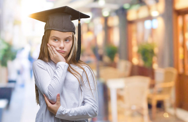 Young beautiful girl wearing graduate cap over isolated background thinking looking tired and bored with depression problems with crossed arms. - Photo, Image