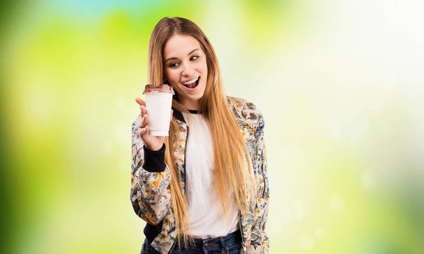 pretty young woman having a coffee on blurred green background - Fotoğraf, Görsel