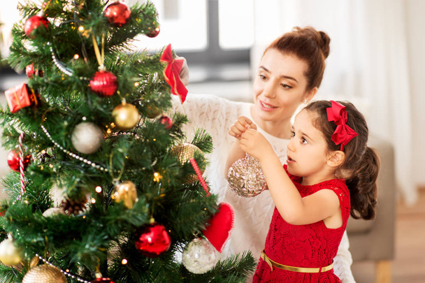 happy family decorating christmas tree at home - Foto, Imagen