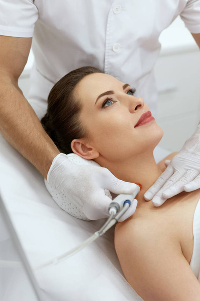Face Skin Treatment. Woman Doing Skin Microdermabrasion Therapy - Фото, зображення