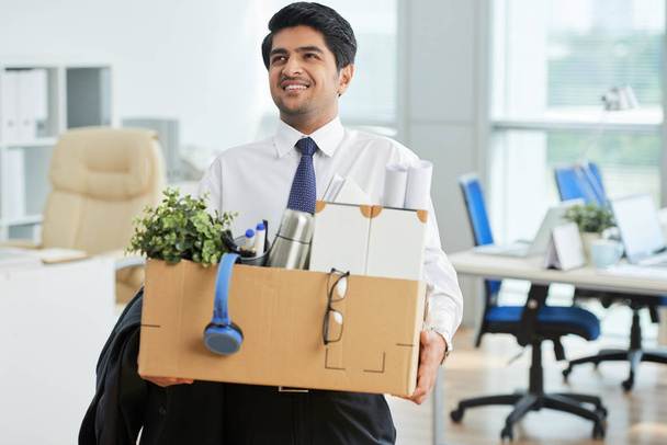 オフィスでのものと段ボール箱を持って幸せのインドのビジネスマン - 写真・画像