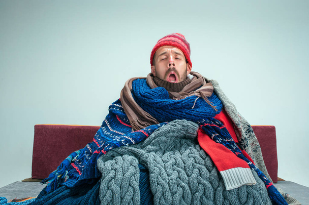 Bearded Man with Flue Sitting on Sofa at Home. Healthcare Concepts. - Valokuva, kuva