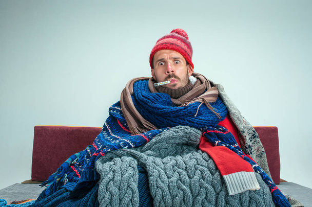 Bearded Man with Flue Sitting on Sofa at Home. Healthcare Concepts. - Fotoğraf, Görsel