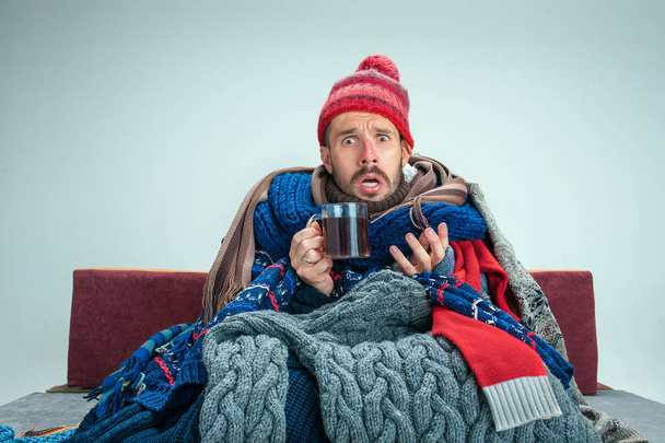 Bearded Man with Flue Sitting on Sofa at Home. Healthcare Concepts. - Φωτογραφία, εικόνα