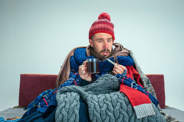 Bearded Man with Flue Sitting on Sofa at Home. Healthcare Concepts. - Photo, image