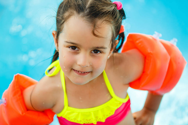 smiling little girl in swimming pool - Fotoğraf, Görsel