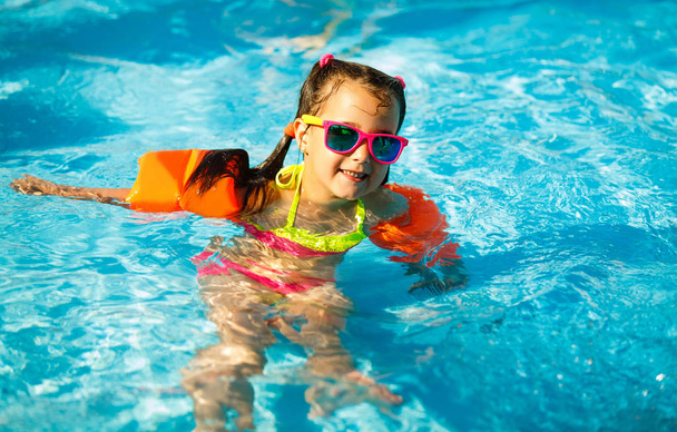 A menina no parque aquático nadando debaixo d 'água e sorrindo
 - Foto, Imagem