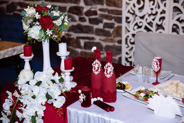 Стол молодоженов украшен цветами, свечами и тканями. Концепция свадебного торжества, праздника, празднования влюбленных, декора
. - Фото, изображение