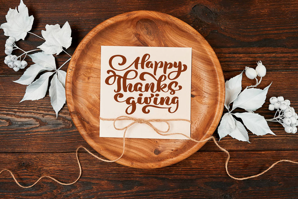 Białe jagody, liny i pozostawia na drewniane tła jesień z tekstem Happy Thanksgiving. Makieta z życzeniami na dzień Dziękczynienia w stylu rustykalnym. Leżał z płaskim. Widok z góry - Zdjęcie, obraz