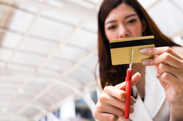Female hands cutting credit card with scissors - 写真・画像