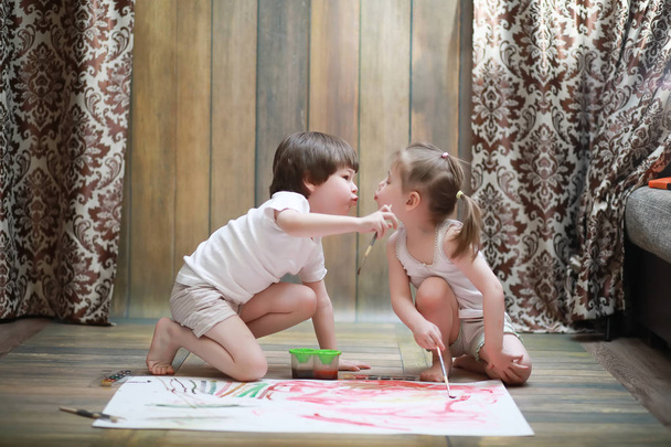Petits enfants peignent sur une grande feuille de papier
 - Photo, image