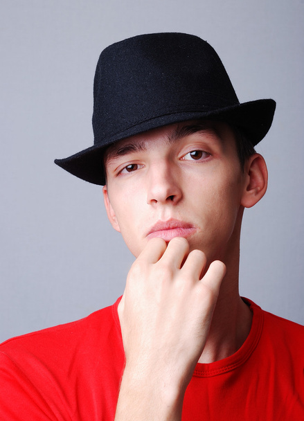 Modelo joven con sombrero en la cabeza y expresión de pensamiento
 - Foto, Imagen