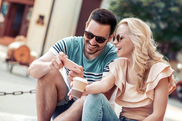 Beau jeune couple prenant selfie avec téléphone intelligent dans la ville
. - Photo, image