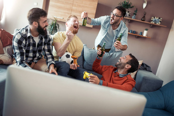 Group of friends playing video games.Young people sitting in the living room and playing together. - Photo, image