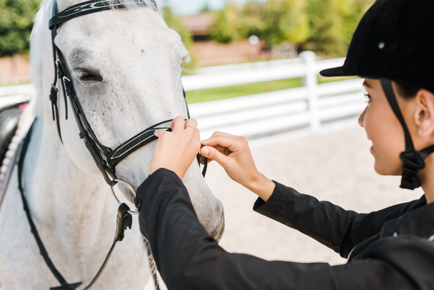 boční pohled na ženské jezdecké upevnění koně ohlávku na koně klubu - Fotografie, Obrázek
