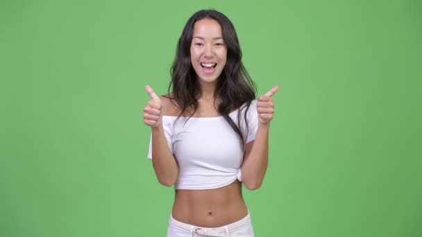 Young happy beautiful multi-ethnic woman looking excited while giving thumbs up - Metraje, vídeo