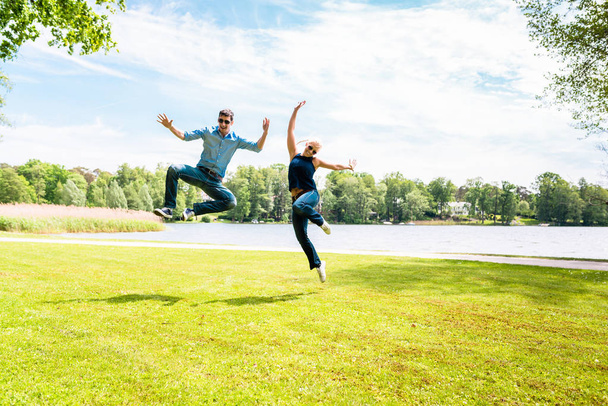 若いカップルのジャンプを興奮 - 写真・画像