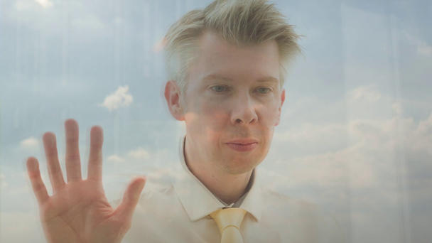 Reflection of a businessman looking out of a window drinking coffee - Materiał filmowy, wideo