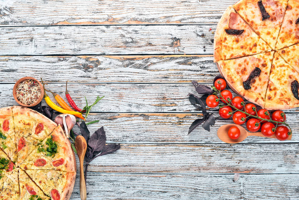 Pizza. Italian cuisine. On a white wooden background. Free space for text. Top view. - Foto, immagini