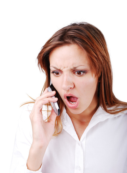 Young brunette with angry expression on face speakin on cell phone - Фото, зображення