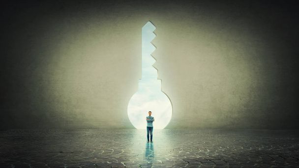 Αυτοπεποίθηση επιχειρηματίας στέκεται μόνος μπροστά σε μια κλειδαρότρυπα σε σχήμα ένας τοίχος από μπετόν. - Φωτογραφία, εικόνα