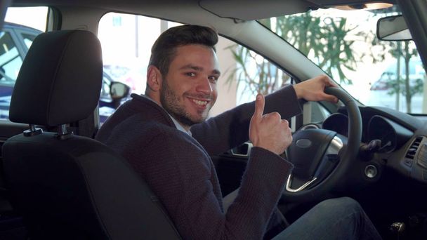 Ember a hüvelykujját mutatja a kocsiban - Fotó, kép