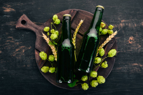 Two bottles of beer On a black wooden table. Free space for text. Top view. - Foto, Imagem