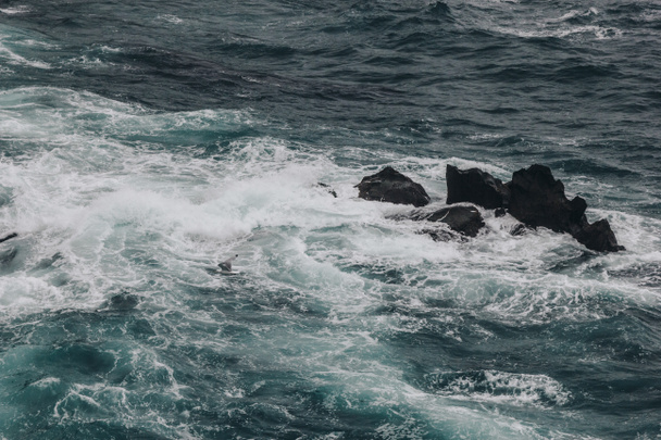 drámai lövés kék óceán hullámai összeomlik, sziklák, háttér - Fotó, kép