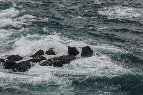 драматический снимок океанских волн, разбивающихся о скалы для фона
 - Фото, изображение