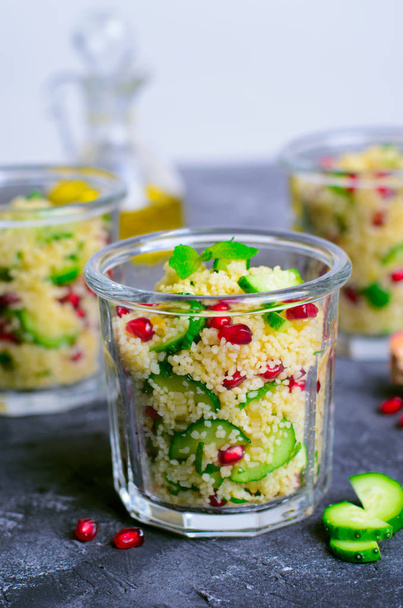 Couscous-Salat im Glas mit Granatapfel, Minze und Gurken, gesunde hausgemachte Kost, vegane Mahlzeit - Foto, Bild