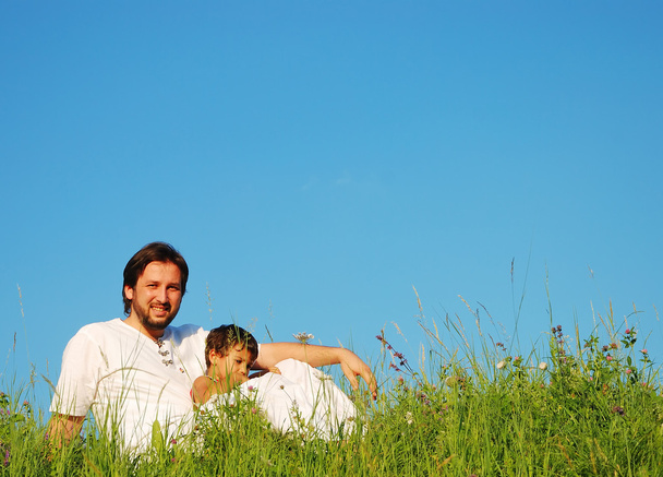 Young father in white with child on beautiful meadow - 写真・画像