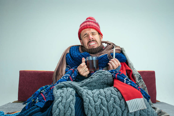Bearded Man with Flue Sitting on Sofa at Home. Healthcare Concepts. - Fotoğraf, Görsel