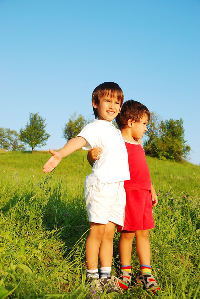 Little cute children on beautiful green field - Foto, Imagen