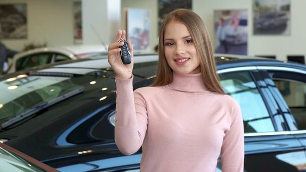 Γυναίκα δείχνει το κλειδί του αυτοκινήτου στην αντιπροσωπεία - Φωτογραφία, εικόνα