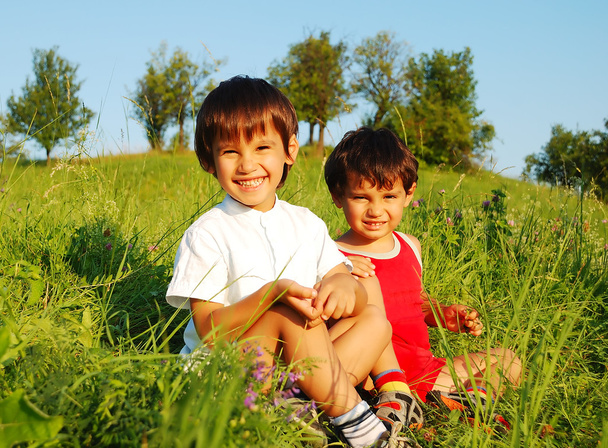 美しい緑の野原で小さなかわいい子供たち - 写真・画像