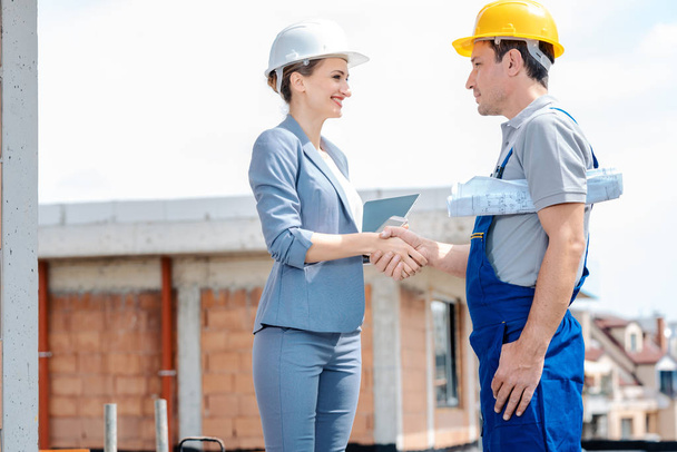 Handshake on construction site between developer and builder - Foto, afbeelding