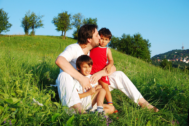 Young father in white with children on beautiful meadow - 写真・画像