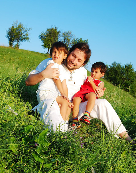 Young father in white with children on beautiful meadow - Zdjęcie, obraz
